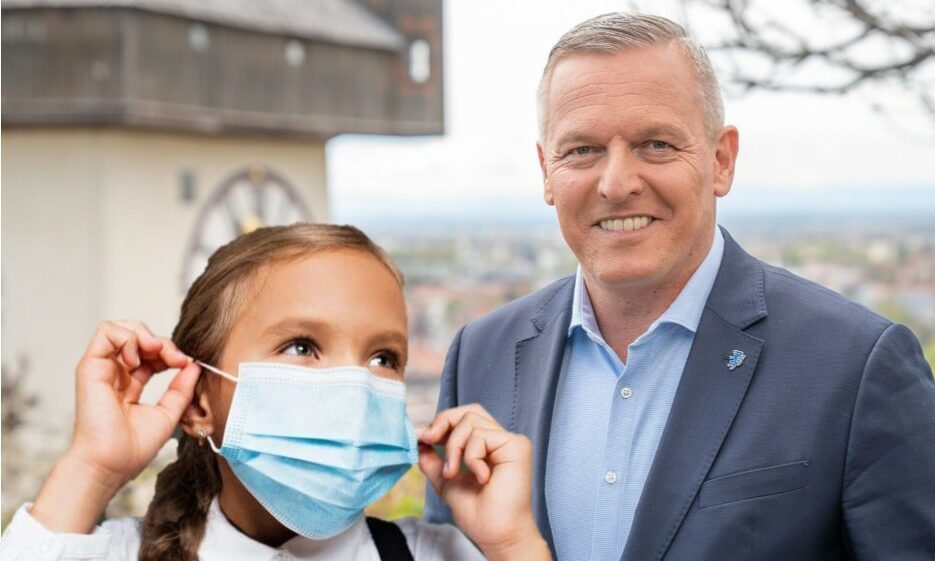 Mario Kunasek und Kind mit Maske